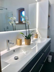 een witte badkamer met 2 wastafels en een spiegel bij Villa Erica in Teltow