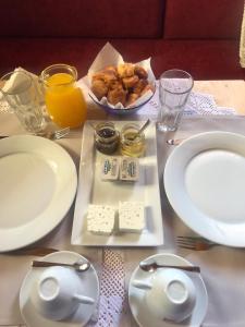 een tafel met witte borden en een kom kaas bij Argyropolis Boutique Hotel in Gjirokastër