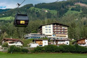 a gondola ride over a village in the mountains at Hotel Waldfriede - Der Logenplatz im Zillertal in Fügen