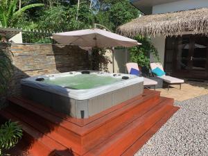 einen Whirlpool mit Sonnenschirm auf einer Terrasse in der Unterkunft Liberdada Suites in Wanica
