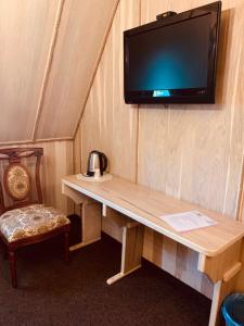 a tv on a wall with a wooden table with a tv on it at Готельно-ресторанний комплекс «Галицький замок» in Ternopilʼ