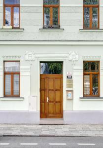 eine Holztür in einem weißen Gebäude mit Fenstern in der Unterkunft Yellow apartment Deluxe in Brünn