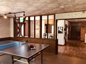 竹田的住宿－赤川温泉スパージュ-Spaju，客厅配有乒乓球桌和桌子