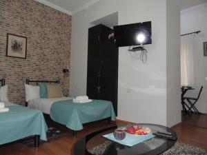 a room with a bed and a television on the wall at Apartment Fine Home in Tbilisi City