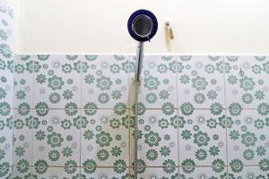 y baño con ducha y azulejos verdes y blancos. en Guest House Taman Sari Syariah, en Parit