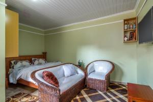 a bedroom with a bed and two chairs at AnD Suites in Nairobi