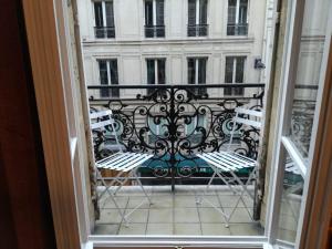 Elle offre une vue sur un balcon avec des chaises et un bâtiment. dans l'établissement Maison de Lignières - Guest House - Paris quartier Champs-Elysées, à Paris