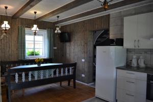 a kitchen with a bench and a white refrigerator at Merkiokrantas Pirkia kaime in Puvočiai