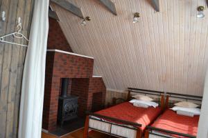 a room with two beds and a brick fireplace at Merkiokrantas Pirkia kaime in Puvočiai