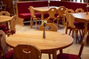 a wooden table with a vase of flowers on it at Pension Kokel in Dumbrăveni +51 photos