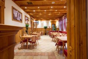 a dining room with wooden tables and chairs at Pension Kokel in Dumbrăveni