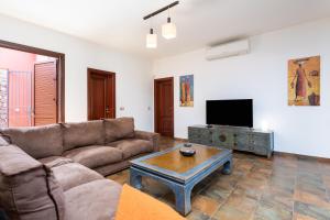 a living room with a couch and a tv at Villa Santa Rosa Tenerife in Tacoronte