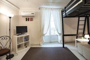 Sala de estar con cama elevada y TV en Trip Rooms, en Palermo