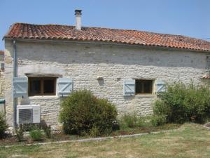 une maison en briques blanches avec deux fenêtres et un toit dans l'établissement Gite du Puits - Bréville, à Bréville