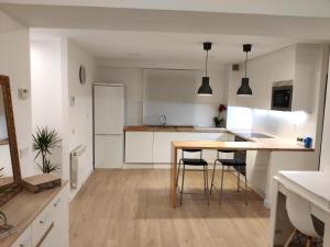 a kitchen with a table and chairs in a room at Apartamento LOS VEGA- parking privado in Oviedo