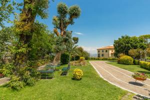 park z ławkami i drzewami oraz budynek w obiekcie Culture Hotel Villa Capodimonte w mieście Napoli