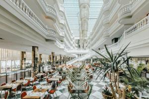 un restaurante con mesas, sillas y plantas en Hotel Cleopatra Palace en Playa de las Americas