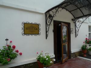 una señal en el lado de un edificio con flores en Hotel Vintage, en Cherepovets