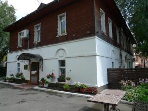 un edificio blanco con flores en la parte delantera en Hotel Vintage, en Cherepovets