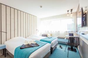 - une chambre avec 2 lits, un bureau et une fenêtre dans l'établissement Opéralia Hôtel les Pins, à Balaruc-les-Bains