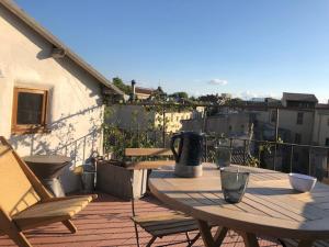 eine Terrasse mit einem Tisch und Stühlen auf dem Balkon in der Unterkunft Appartement avec terrasse panoramique au coeur de Nîmes in Nîmes