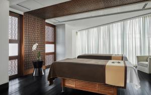 1 dormitorio con 1 cama grande y 1 silla en Four Seasons Hotel Abu Dhabi at Al Maryah Island, en Abu Dabi