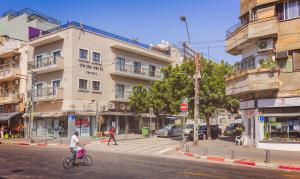 a person riding a scooter on a city street at Kalvin Boutique Hotel by Levinsky Market Tel-Aviv in Tel Aviv