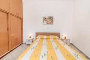 a bedroom with a large bed with a yellow blanket at ''Cactaki'' Studio in Vólax
