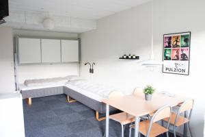 a living room with a couch and a table at Pulzion - Sportshotel in Kolding