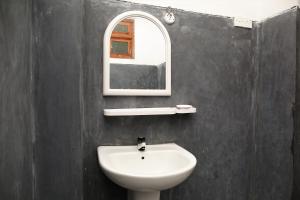 y baño con lavabo blanco y espejo. en Mountain Relax Inn, en Weligama