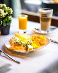 a plate of breakfast food on a table with two drinks at Glärnischhof by TRINITY in Zurich