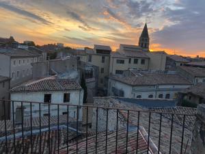 - une vue sur une ville au coucher du soleil avec une église dans l'établissement Appartement avec terrasse panoramique au coeur de Nîmes, à Nîmes