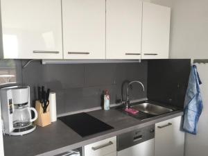 a kitchen with white cabinets and a sink and a blender at Ferienwohnung Reinhold in Sankt Englmar