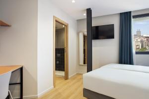 a bedroom with a white bed and a window at Hotel Brick Barcelona in Barcelona