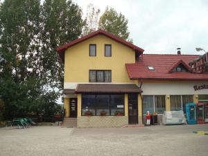 een geel huis met een rood dak bij Pensiunea Marc in Suceava