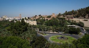 a city with a fountain in the middle of a street at Hotel MS Maestranza Málaga in Málaga
