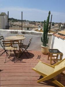 un patio con mesa, sillas y cactus en Appartement avec terrasse panoramique au coeur de Nîmes en Nimes