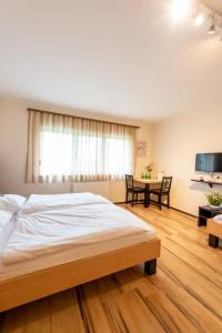 1 dormitorio con 1 cama grande y 1 mesa en Gästehaus Moser, en Mönchhof