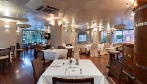 a dining room with white tables and chairs at Hotel MS Maestranza Málaga in Málaga