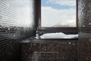 a bath tub sitting next to a wall with water coming out of it at Grau Roig Andorra Boutique Hotel & Spa in Grau Roig
