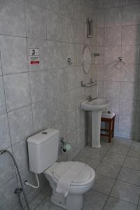 La salle de bains est pourvue de toilettes et d'un lavabo. dans l'établissement Pousada Da Luz Carapibus, à Jacumã