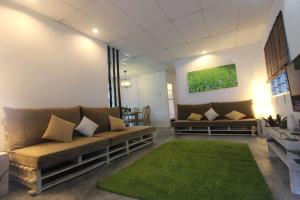a living room with a couch and a green rug at Tung's Factoria Cameron Highland in Cameron Highlands