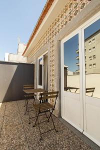 een patio met een tafel en stoelen op een balkon bij The Gate in Porto
