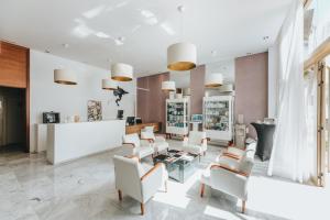 a salon with white chairs and a table at Hotel Cleopatra Palace in Playa de las Americas