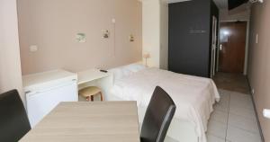 Schlafzimmer mit einem Bett, einem Schreibtisch und einem Tisch in der Unterkunft Hotel De Zeebries Budget in Middelkerke