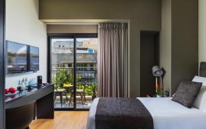 um quarto de hotel com uma cama e uma varanda em Kalvin Boutique Hotel by Levinsky Market Tel-Aviv em Tel Aviv