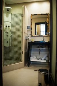 a bathroom with a shower and a sink and a mirror at Andromeda Hotel Thessaloniki in Thessaloniki