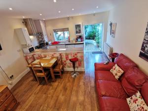 a living room with a red couch and a kitchen at The Garden in Barrow in Furness