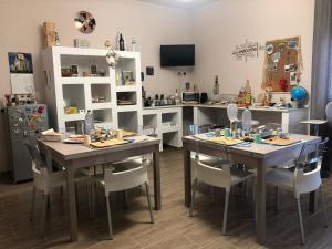 ein Esszimmer mit Tischen und Stühlen sowie eine Küche in der Unterkunft Holidays Lecce in Lecce