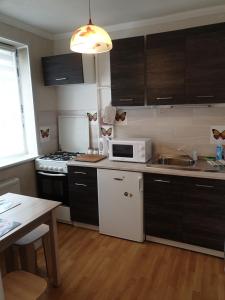 a kitchen with a white microwave and a stove at Rose apartaments in Liepāja